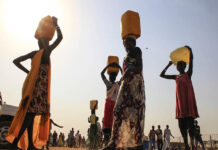 South Sudan: From war to water crisis Displaced people carry water containers on their heads at Tomping camp