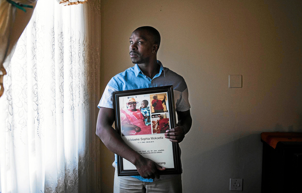 Heartbroken: Frans Makoetla holds a portrait of his mother.