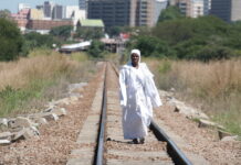 Mothers and babies at risk in Apostolic church ‘birth camps’ An Apostolic woman walks along train tracks on her way back from a mountain prayer session.