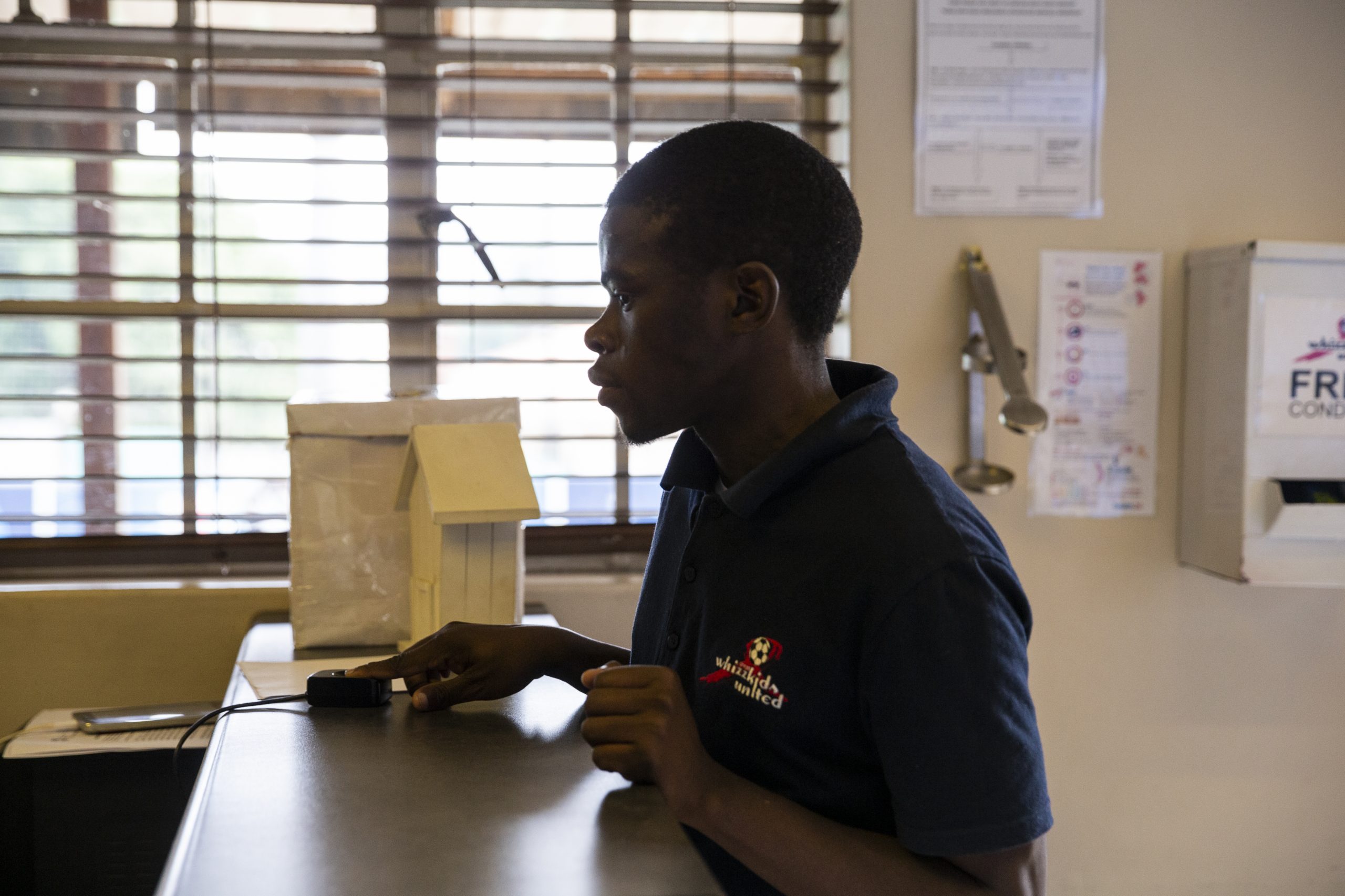 Man scans his fingerprint to receive medication.